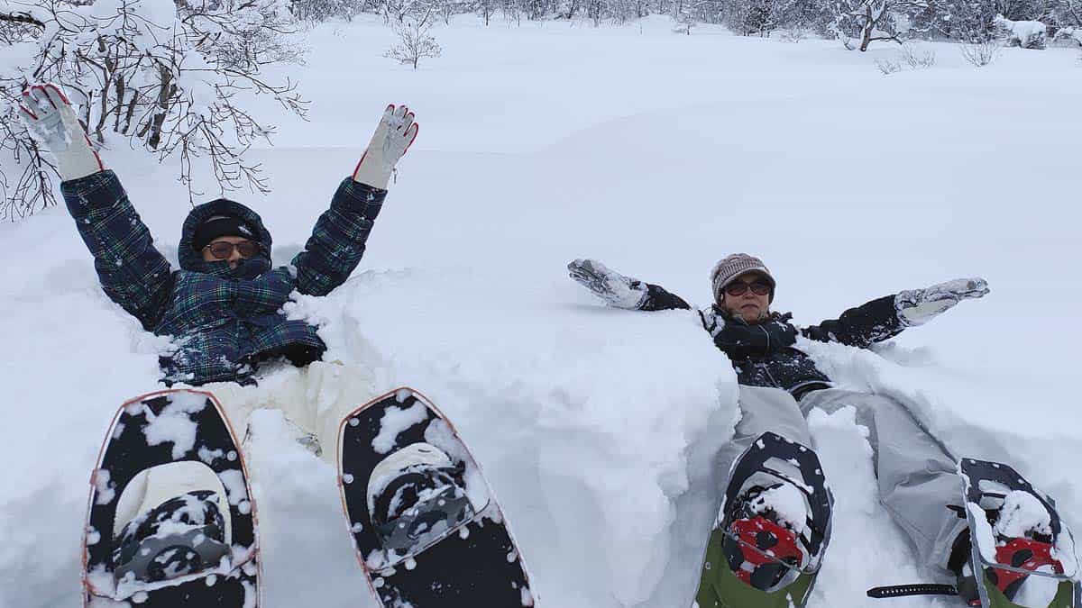two people lying in the snow