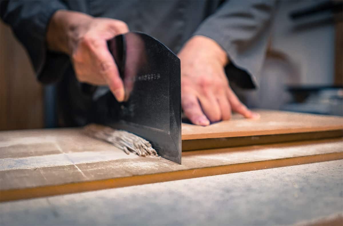 cutting soba noodles with a knife.